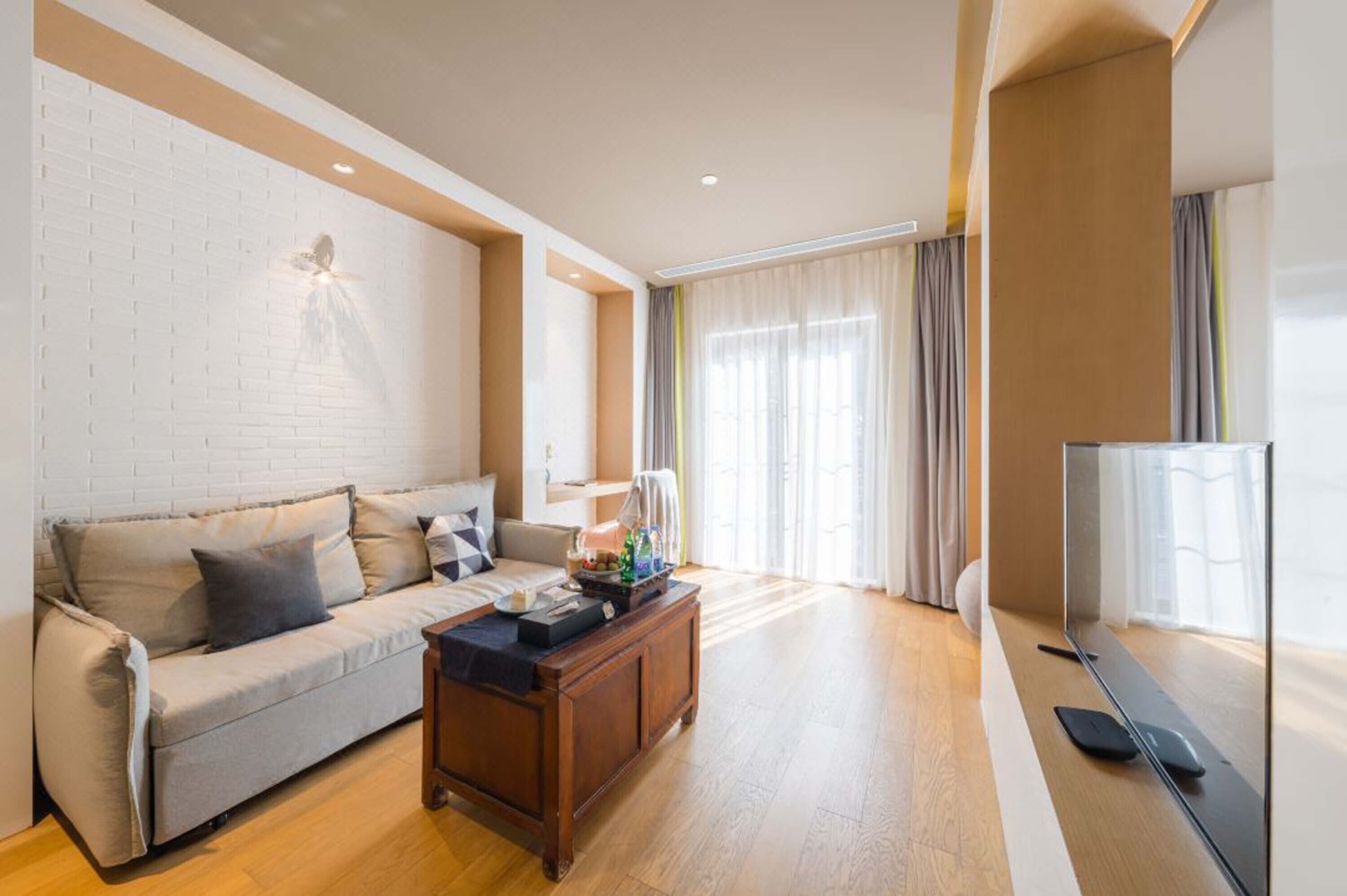 A modern living room with a sofa, coffee table, and a flat-screen TV.