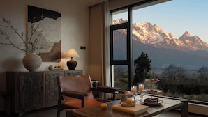 A modern living room with a large window overlooking a mountainous landscape.