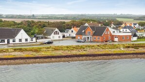 A coastal residential area with houses, a road, and a railway track.