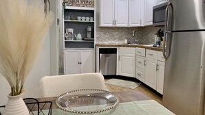 A kitchen with white cabinets, a stainless steel refrigerator, a microwave, and a dishwasher. - Stylish Studio in Old Colorado City-Shops and Dining Only Steps Away! (Colorado Springs)