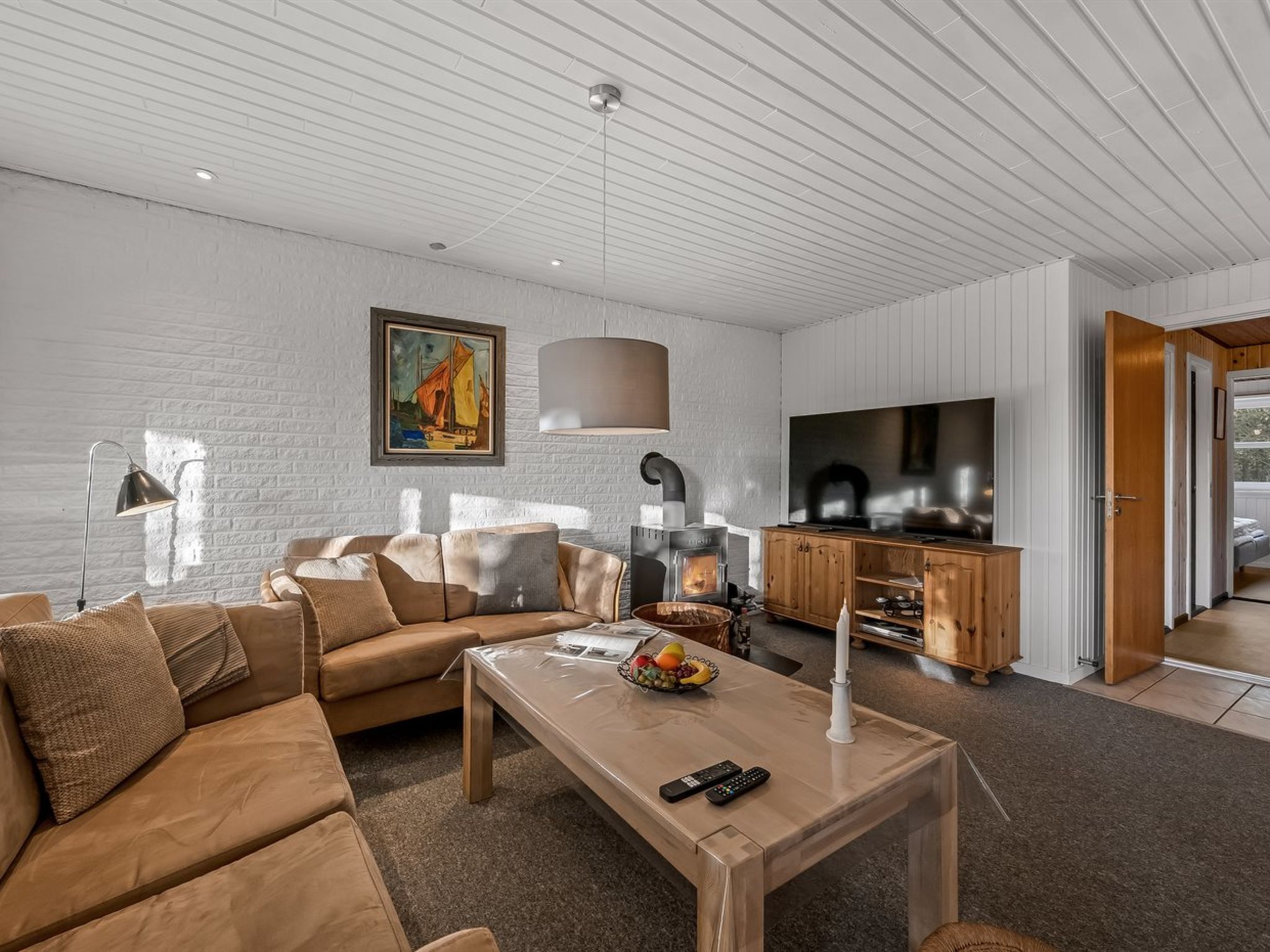 Un salon moderne avec un canapé, une table basse et une cheminée.