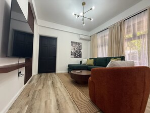 Condo de lujo, 2 habitaciones | Área de sala de estar | Smart TV de 65 pulgadas con canales digitales y Netflix