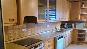 A kitchen with wooden cabinets, a microwave, a stove, and a dishwasher.