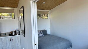 A bedroom with a bed, a dresser, and a window.