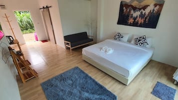 A bedroom with a bed, a desk, a chair, a window, and a painting on the wall.