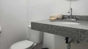 A bathroom with a toilet, sink, and mirror. - A HOME AWAY FROM HOME (Lima)