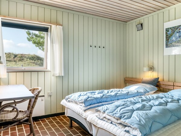 Une chambre à coucher avec un lit, une table et une chaise.