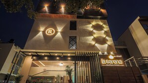 L’entrée d’un hôtel de charme, dotée d’un design moderne, se distingue par un logo bien visible, une entrée sécurisée par un portail et une enseigne indiquant qu’il s’agit d’un hôtel de charme.