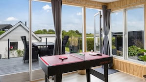 A modern room with a ping pong table, large windows, and a view of the outdoors. - "Arnia" - 250m from the sea by Interhome (Hejls)