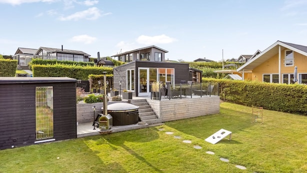A modern residential area with a well-maintained lawn, outdoor seating, and a hot tub. - "Arnia" - 250m from the sea by Interhome (Hejls)