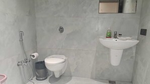 A modern bathroom with a toilet, bidet, and sink. - Hotel Downtown (Bilaspur)