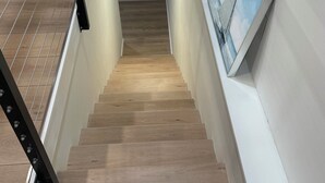 Un escalier avec des marches en bois et une rampe en métal noir.