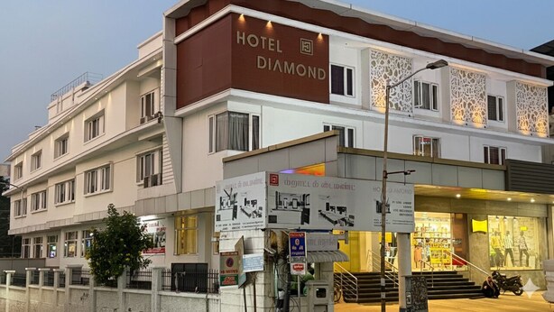 Um hotel com vários andares chamado 'Hotel Diamond', com fachada moderna, varandas e entrada bem iluminada.