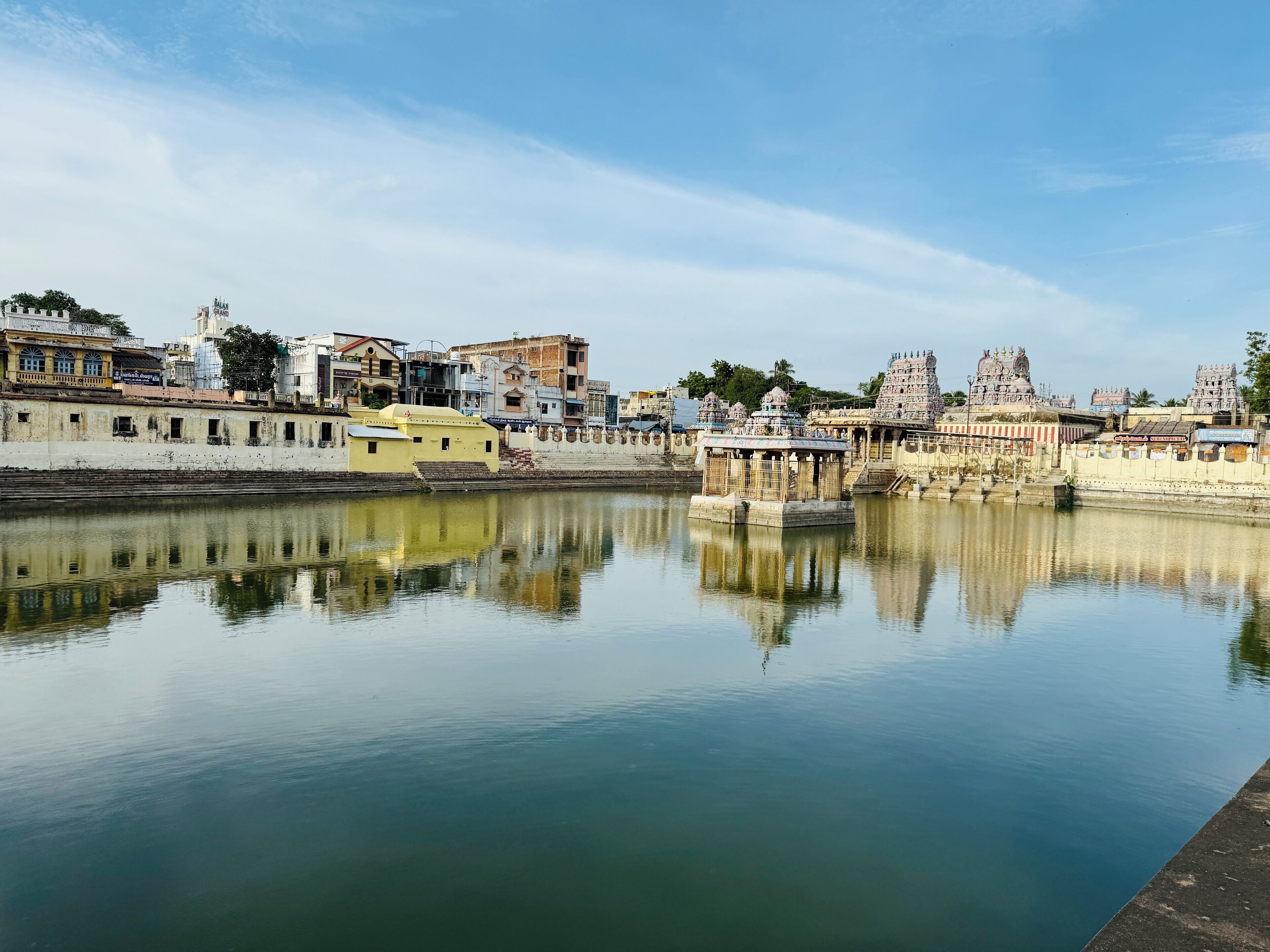 Un río tranquilo con edificios y templos a la vista en la otra orilla.