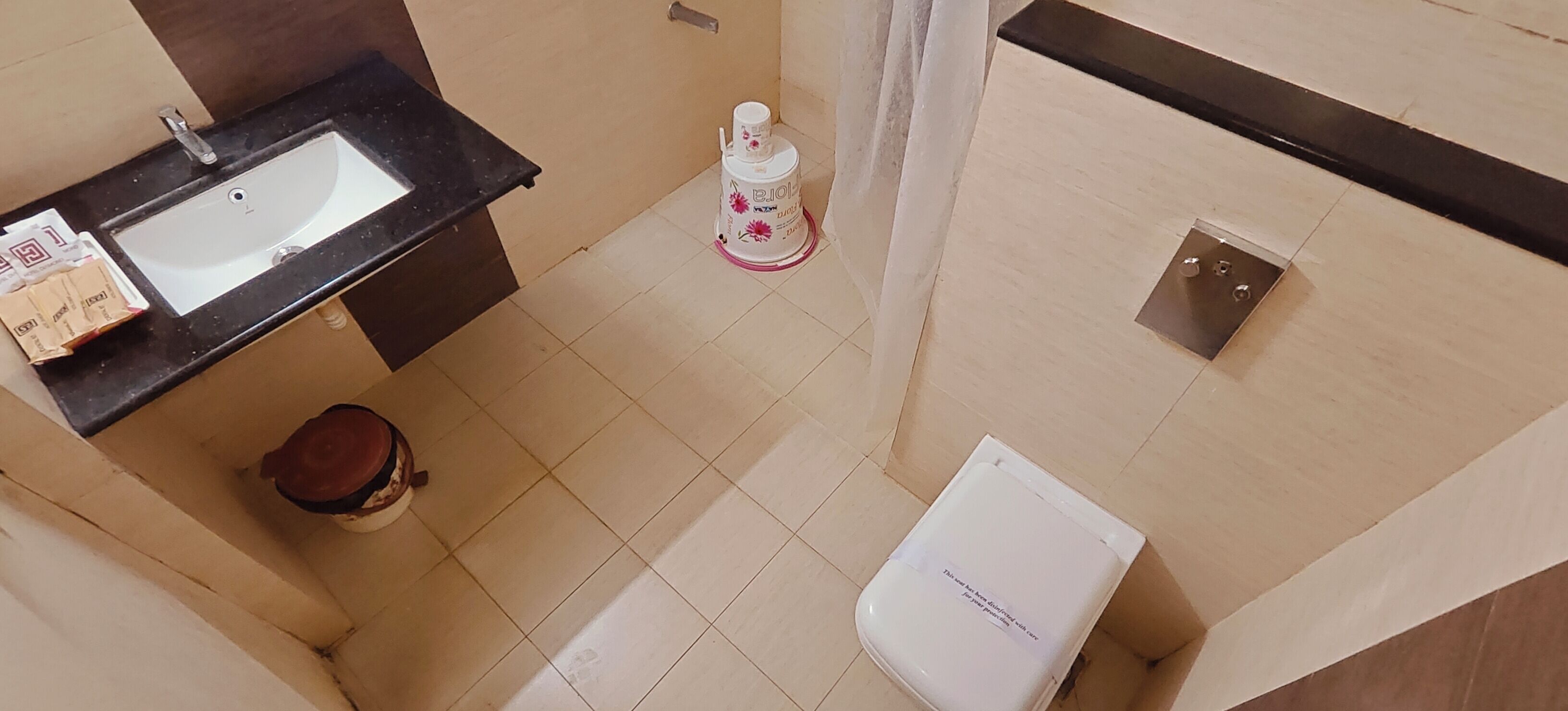 Un baño pequeño con lavamanos, inodoro y un cubo de basura.