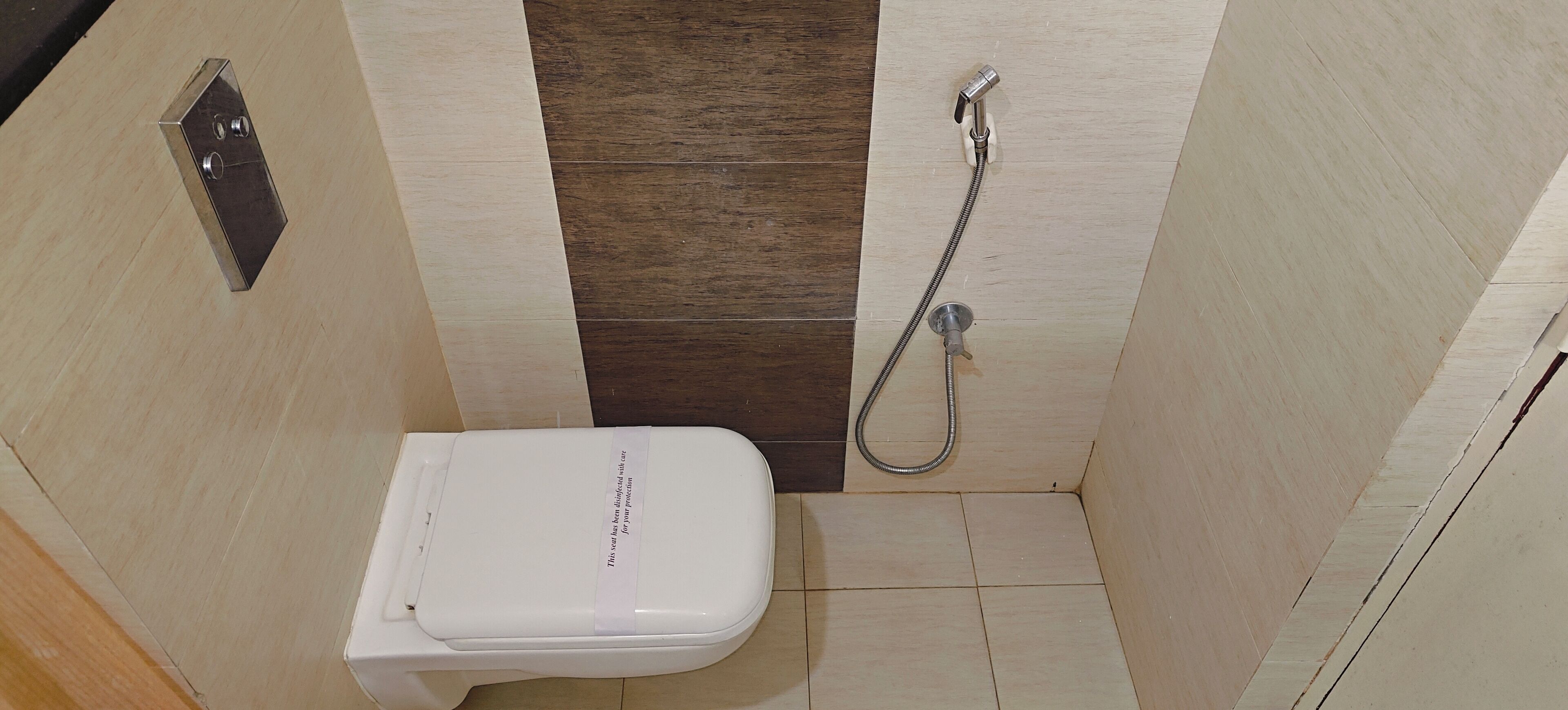 A small, narrow bathroom with a toilet, a shower, and a towel rack.