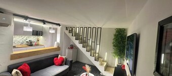 Warm, modern studio with designer staircase.