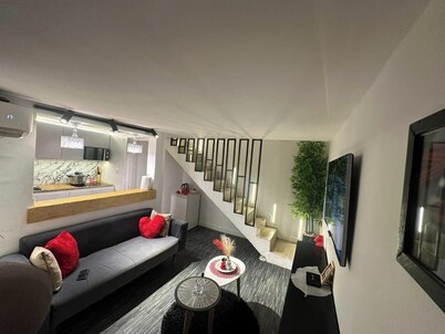 Warm, modern studio with designer staircase.