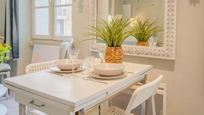 Ein Esstisch mit weißen Tellern, Gläsern und einem gewebten Blumentopf.