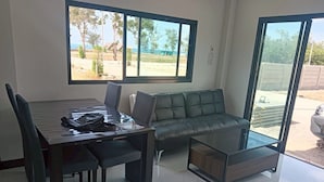 Un salon moderne avec une table à manger, un canapé et une table basse en verre.