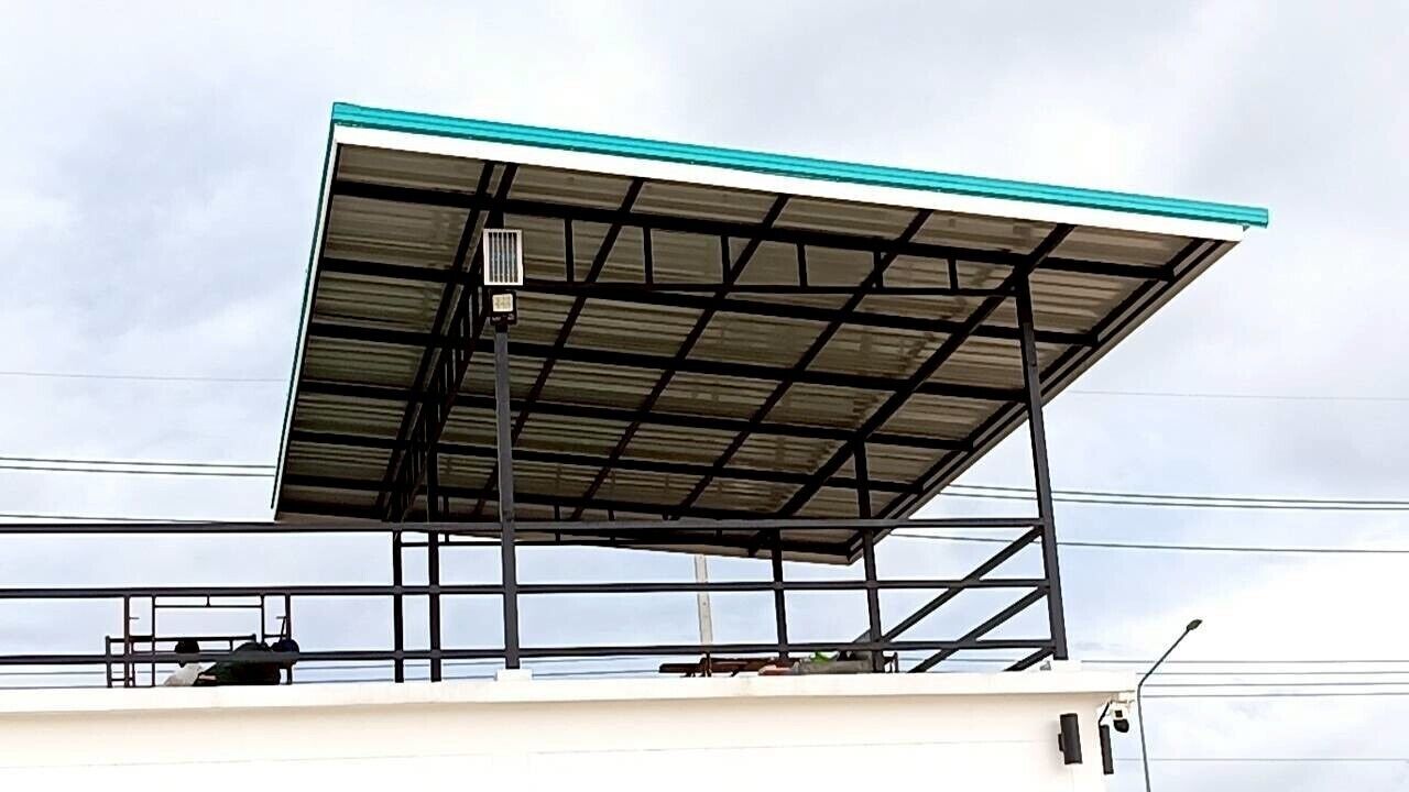 Un edificio con estructura metálica y techo plano.