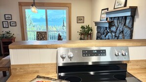 Une cuisine équipée d’une cuisinière, d’un four et d’une pizza sur une plaque.