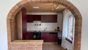 Una cocina con arco de ladrillo, encimera de madera y muebles de cocina modernos.