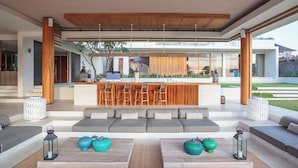 A modern living area with a bar, seating, and a view of the outdoors. - The Iman Villa by Elite Havens (Kabupaten Badung)