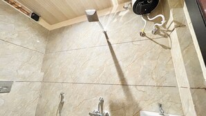 A bathroom with a shower, a sink, and a security camera. - Shree Sawariya Palace (Ujjain)