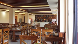 Un restaurante con muebles de madera, una zona de bar y una pared con diseño.