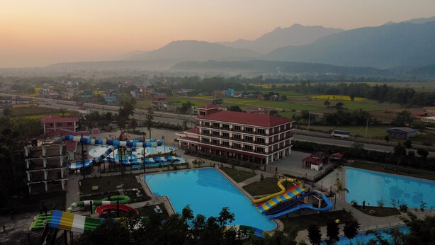 Un resort con varias piscinas, toboganes acuáticos y un edificio grande con balcones.