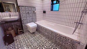 Un baño con una bañera blanca, un inodoro blanco y un lavabo.