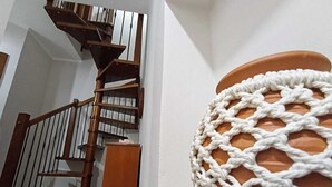 A staircase with wooden railings and a terracotta pot wrapped in white macramé. - Polizzihouse - Holiday House with Panoramic Terrace, in the Heart of the Madonie Mountains. (Polizzi Generosa)