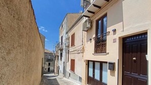 A narrow street with buildings on either side, featuring stone-paved ground and traditional architecture. - Polizzihouse - Holiday House with Panoramic Terrace, in the Heart of the Madonie Mountains. (Polizzi Generosa)
