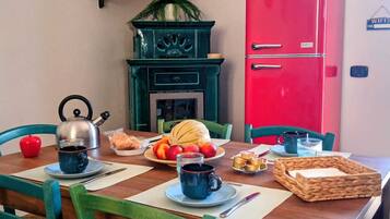 A dining table set with a kettle, teapot, plates, cups, and food items.