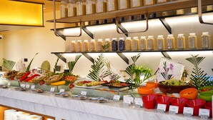 Un bufé con diversos alimentos y acompañamientos, incluyendo frascos con cereales y una variedad de frutas y verduras frescas.