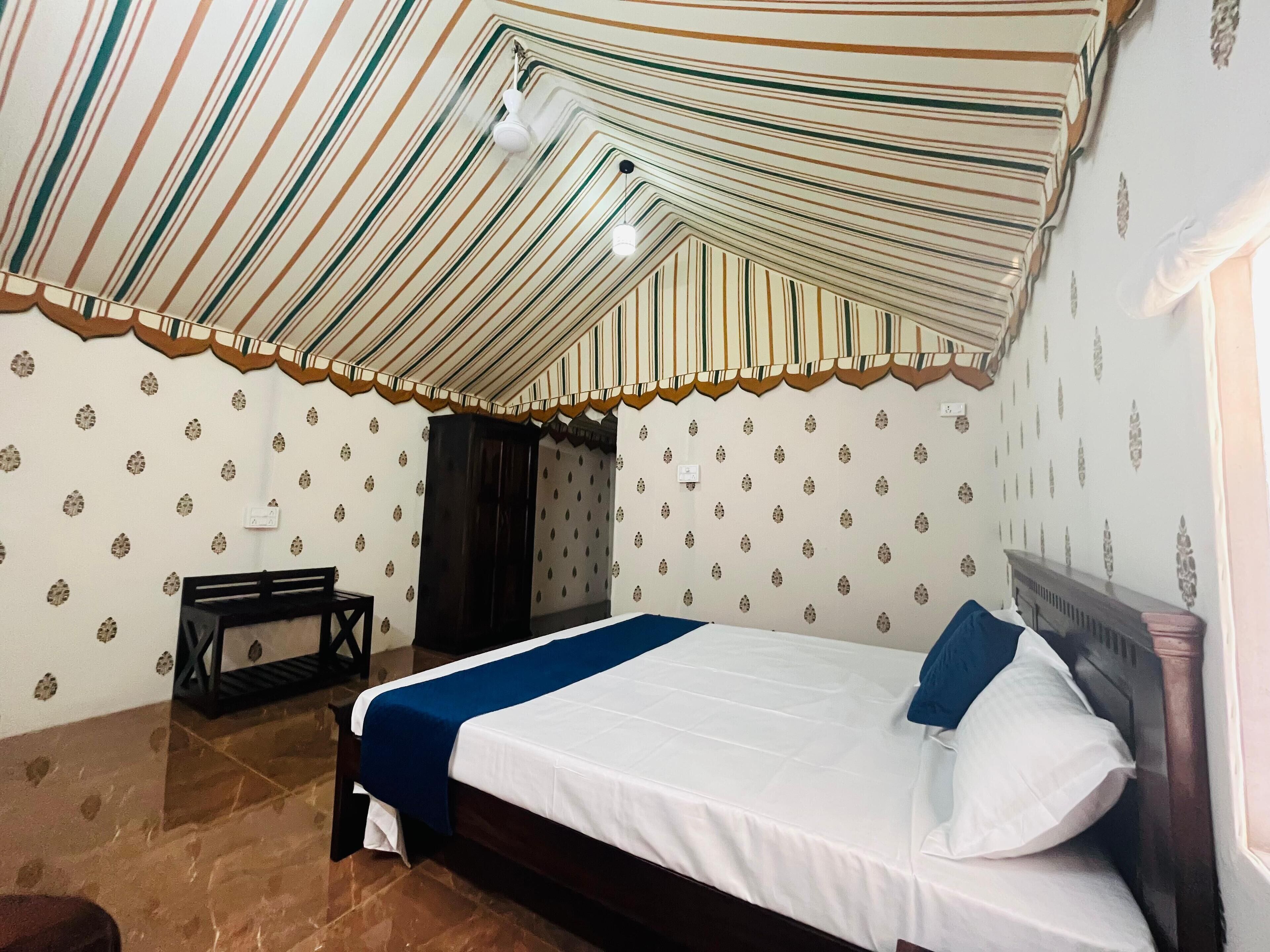 Una habitación con cama, armario y techo a rayas.