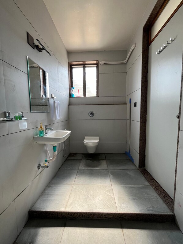 Un baño pequeño y moderno con lavamanos, espejo e inodoro.