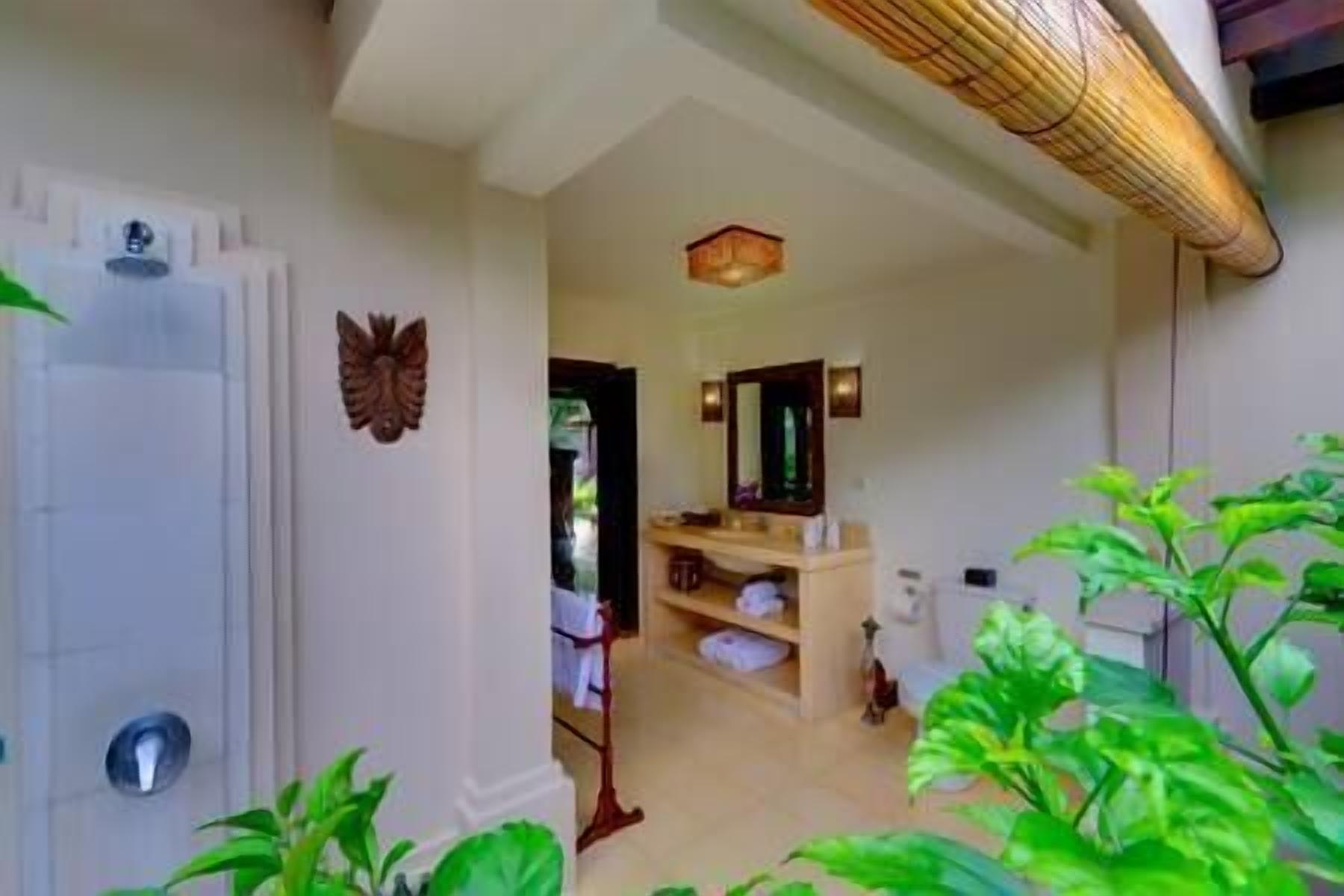 A bathroom with a large mirror, a towel rack, and a shower area.