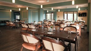 A spacious dining area with multiple tables and chairs, ceiling fans, and pendant lights. - Cilantro Unwind Delisso Abode Pelling (Gyalshing)