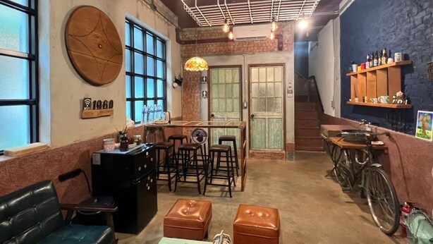 Un café accueillant avec un coin bar, des places assises et un porte-vélos.
