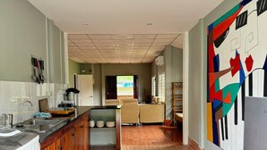Une cuisine spacieuse avec des meubles en bois, un îlot central et un tapis aux couleurs vives.