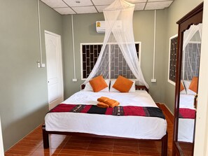 A bed with a canopy, a bedside table, and a mirror. - kiwi villas 1 (Vang Vieng)