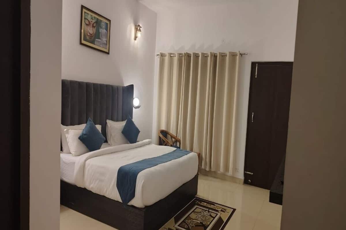 Une chambre à coucher avec un lit, une chaise, une porte et un rideau.