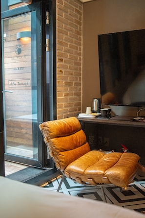 A room with a leather chair, a television, and a brick wall. - Gwangju Awesome Boutique Hotel (Gwangju)