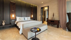 A hotel room with a large bed, bedside lamps, a small round table with a book and a flower, and a decorative vase.