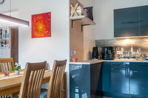 Eine moderne Küche mit Geschirrspüler, einer Kaffeemaschine und Blick auf die Stadt.