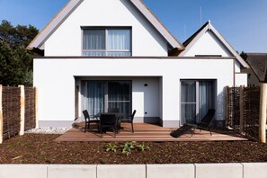 Una casa moderna de dos pisos con un patio, comedor y zona de estar.