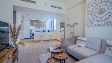 Apartamento luxo, 1 quarto, sacada, vista para a cidade | Área de estar | Smart TV 55 polegadas com canais digitais