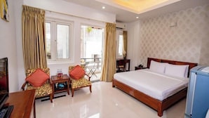 A hotel room with a bed, two chairs, a small table, a desk, and a television. - Ben Thanh Retreats Hotel (Ho Chi Minh City)